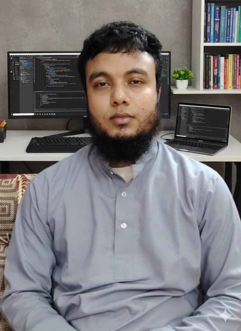 Abdul Mazid at his desk in Sylhet, Bangladesh, with an editor open on the monitor behind him